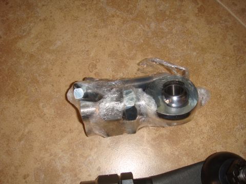 1992 Ford Bronco - A metal automotive part, likely a suspension component, is shown wrapped in plastic on a tiled surface.
