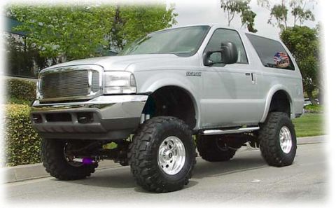 1995 Ford Bronco - This silver Ford Excursion features a lifted suspension and oversized tires, indicating a model year around 2000.