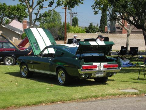 1992 Ford Crown Victoria - A green 1968 Shelby GT500 Mustang is displayed with its trunk and hood open at a car show.