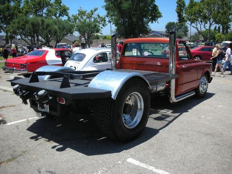 1992 Ford Crown Victoria - Custom flatbed truck with prominent exhaust pipes parked at an outdoor event.