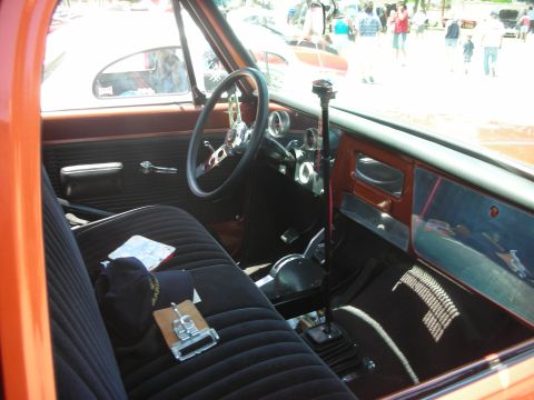 1992 Ford Crown Victoria - The interior of a vintage pickup truck features a bench seat, custom steering wheel, and a floor-mounted shifter.