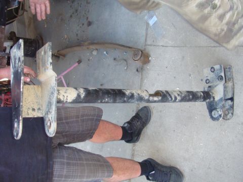 1992 Ford Bronco - A dirty vehicle axle assembly is shown on a concrete surface, with a person's legs visible.
