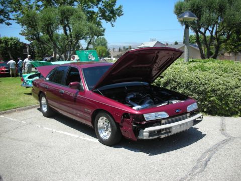 1992 Ford Crown Victoria - Maroon 1992 Ford Crown Victoria at a car show with its hood open, revealing engine work.