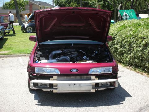 1992 Ford Crown Victoria - This customized 1992 Ford Crown Victoria features a prominent turbocharger under its open hood, displayed at an outdoor car event.