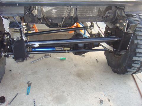 1992 Ford Bronco - Close-up view of a vehicle's suspension system, showing heavy-duty components and a steering stabilizer.
