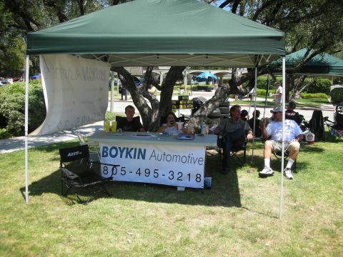 1992 Ford Crown Victoria - A booth at an outdoor event features a table with "BOYKIN Automotive" and a phone number displayed on a banner.