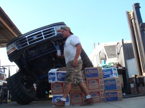1992 Ford Bronco - A man stands next to a heavily modified 1992 Ford Bronco, surrounded by cases of beer.
