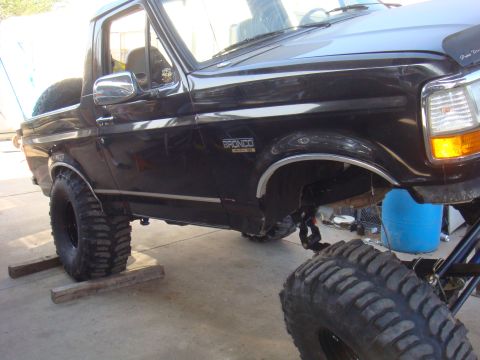 1992 Ford Bronco - A black 1992 Ford Bronco is shown with a lifted suspension and large off-road tires.