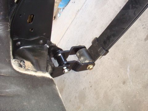 1992 Ford Bronco - Close-up of a vehicle's rear suspension leaf spring and shackle mount assembly.