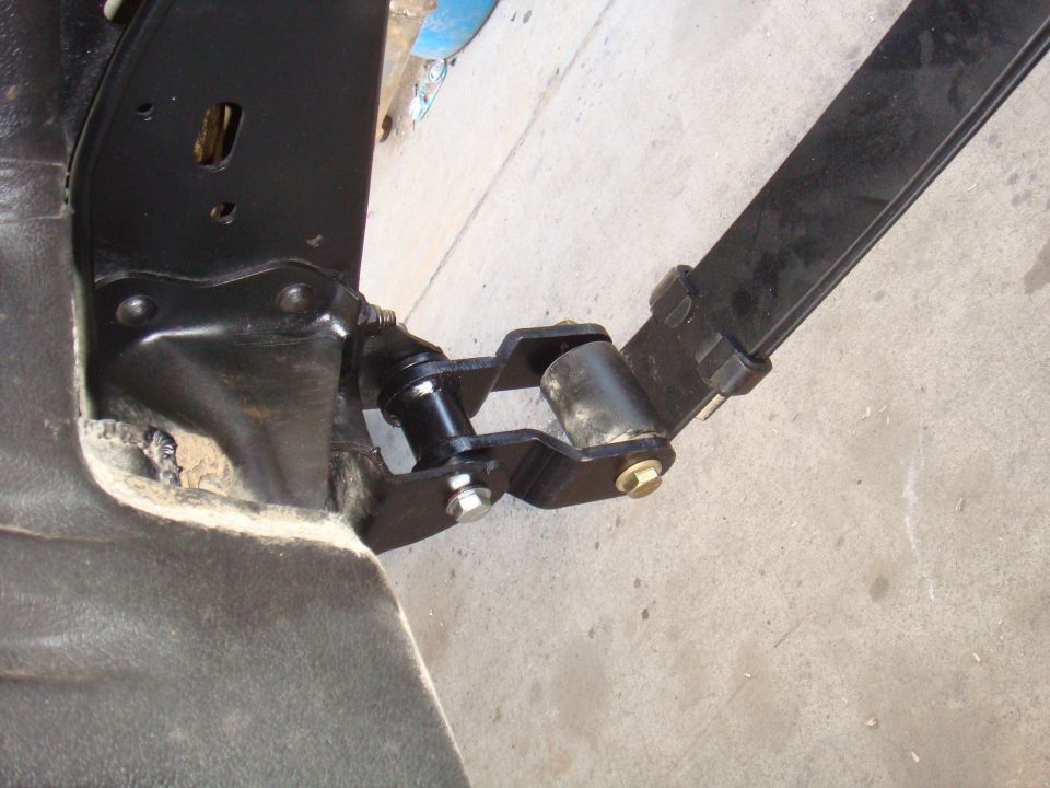 Leaf spring attached to shackle mount with bushings and bolts
