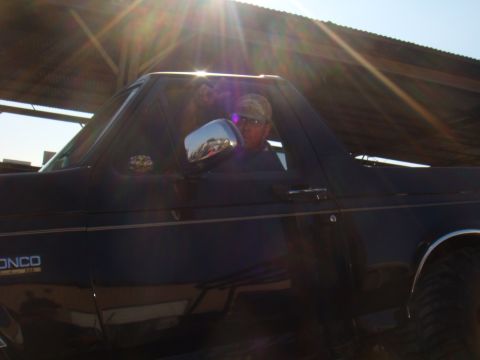 1992 Ford Bronco - A man sits in the driver's seat of a dark blue 1992 Ford Bronco.