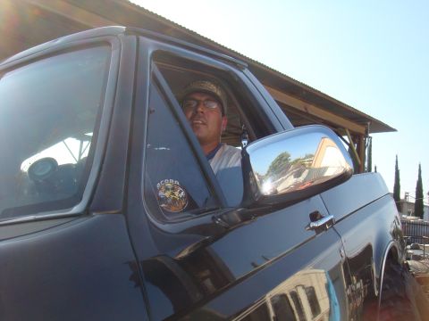 1992 Ford Bronco - A man sits in the driver's seat of a black SUV, with an "ACORN" sticker visible on the door panel.