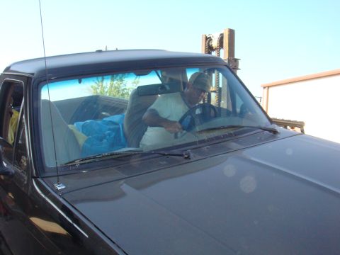1992 Ford Bronco - A man drives a black 1992 Ford Bronco, with a blue tarp visible in the passenger seat.