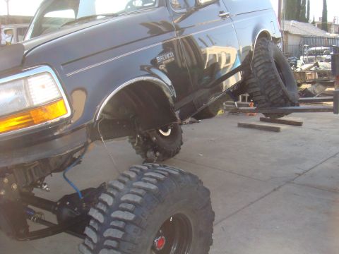 1992 Ford Bronco - This black 1992 Ford Bronco features a significantly lifted suspension and massive off-road tires, indicating custom axle work.
