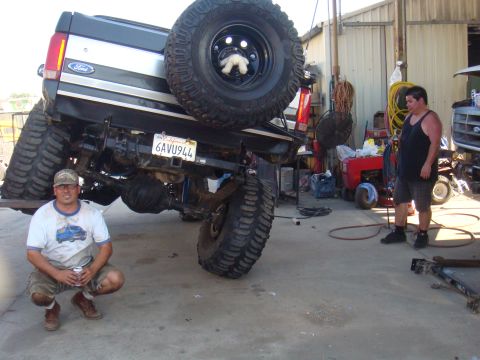 1992 Ford Bronco - A modified 1992 Ford Bronco is shown with its rear end lifted, oversized tires and suspension modifications.