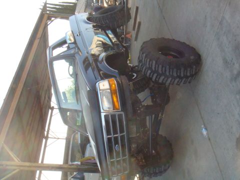 1992 Ford Bronco - This modified Ford truck features a lifted suspension and aggressive off-road tires, suggesting it's built for terrain.