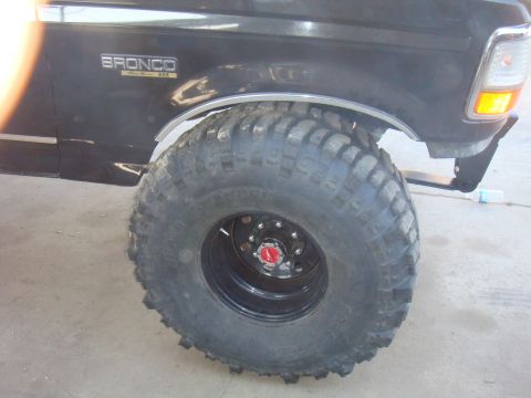 1992 Ford Bronco - Close-up of a black 1992 Ford Bronco's front fender and large tire.