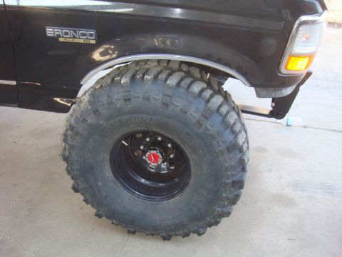 1992 Ford Bronco - This 1992 Ford Bronco features a prominent "BRONCO" badge and is equipped with oversized off-road tires.