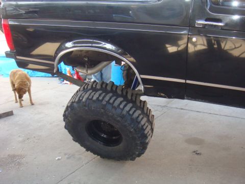 1992 Ford Bronco - 1992 Ford Bronco lifted with a large off-road tire and exposed rear axle.