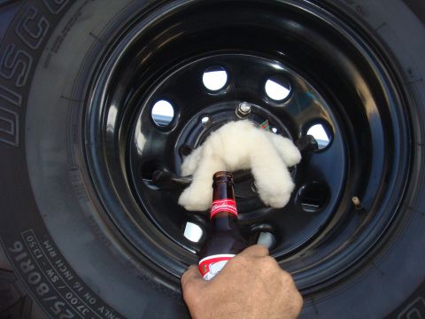 1992 Ford Bronco - A tire and wheel assembly is shown with a beer bottle and a stuffed animal.