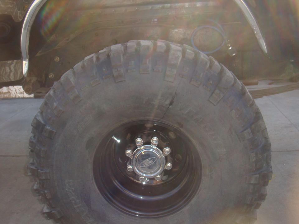 1992 Ford Bronco front wheel and fender well. Chrome Ford hubcap visible