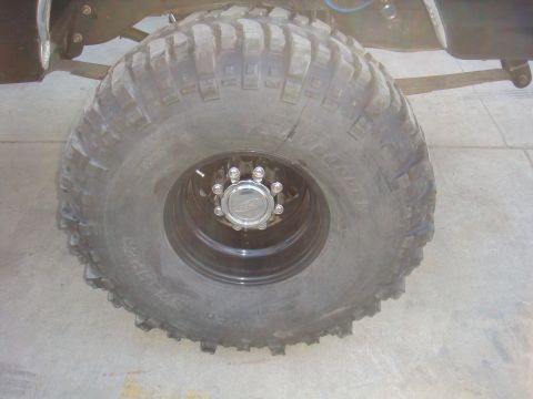 1992 Ford Bronco - This photo shows a close-up of a large off-road tire and wheel assembly, with some suspension components visible.