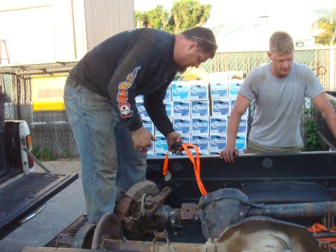 1992 Ford Bronco - Loading vehicle axles into a truck bed, with a stack of Bud Light cases behind them.