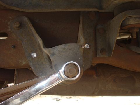 1992 Ford Bronco - A wrench is used to tighten a bolt on a rusty vehicle suspension component.