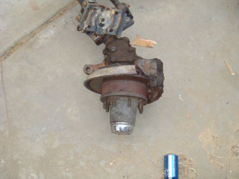 1992 Ford Bronco - A disassembled front axle assembly rests on a concrete surface, showing signs of wear and rust.