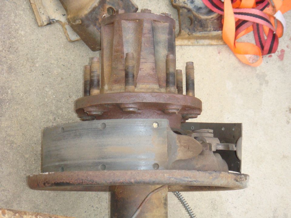 Close-up of a rusty vehicle axle hub with multiple lug bolts