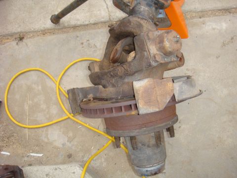 1992 Ford Bronco - Front axle assembly with brake rotor and yellow hose, likely from a truck or SUV.