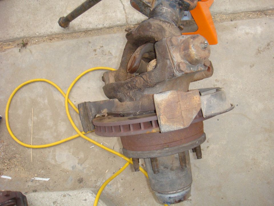 Front axle assembly with brake rotor and yellow hose