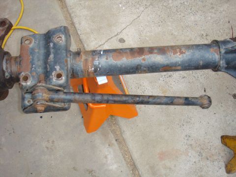 1992 Ford Bronco - A rusty front axle assembly is supported by an orange jack stand on a concrete surface.