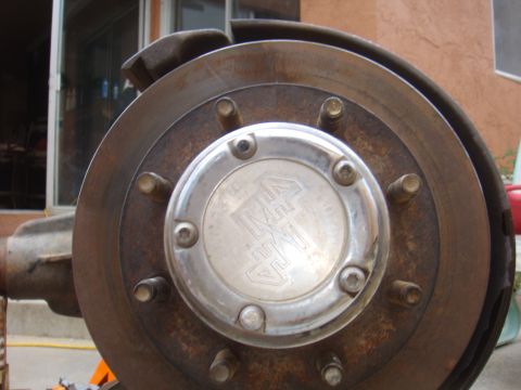 1992 Ford Bronco - Close-up of a wheel hub and brake rotor, a metal cap with a logo.