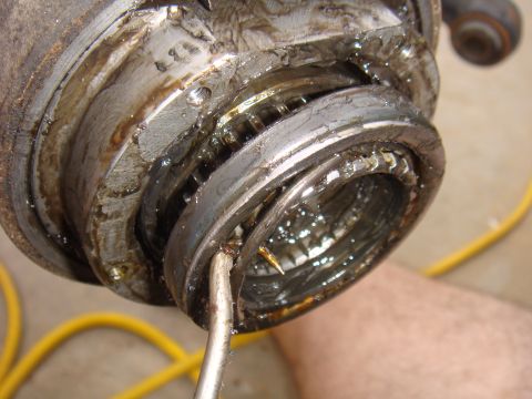 1992 Ford Bronco - A damaged wheel bearing assembly is examined, revealing significant wear and debris within its components.
