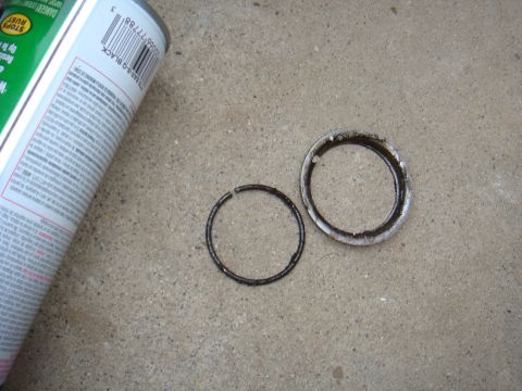 1992 Ford Bronco - Two worn axle seals are shown next to a can of spray paint on a concrete surface.