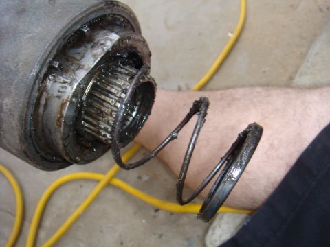 1992 Ford Bronco - Close-up of a greasy axle part showing a broken spring.