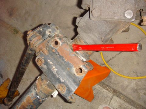 1992 Ford Bronco - Close-up of a rusted axle part being worked on with a chisel.