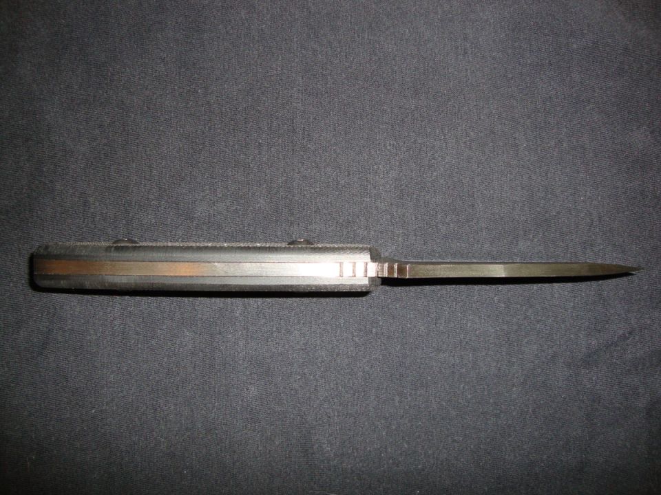 Open folding pocket knife lying on dark blue cloth