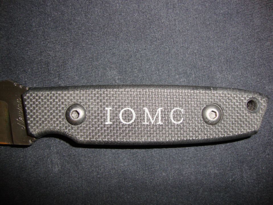 Black knife with textured handle engraved IOMC