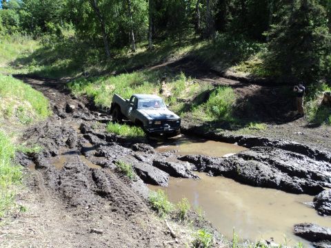 1990 Chevrolet Suburban - A pickup truck navigates a difficult muddy obstacle course.