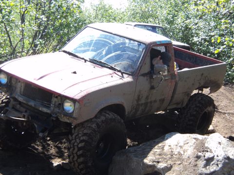 1990 Chevrolet Suburban - This heavily modified pickup truck is shown off-roading on a rocky trail.