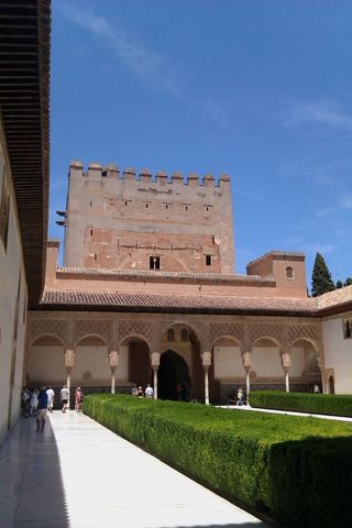 1991 Ford LTD Crown Victoria - A view of the Alhambra palace in Spain, a prominent tower and ornate arched walkways with manicured gardens.