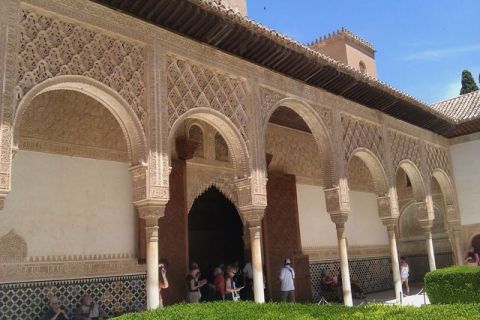 1991 Ford LTD Crown Victoria - Intricate architectural details of a historic building, likely in Spain, with visitors exploring the grounds.