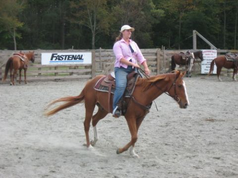 1991 Ford Bronco - A woman rides a horse in an outdoor arena, with other horses visible in the background.