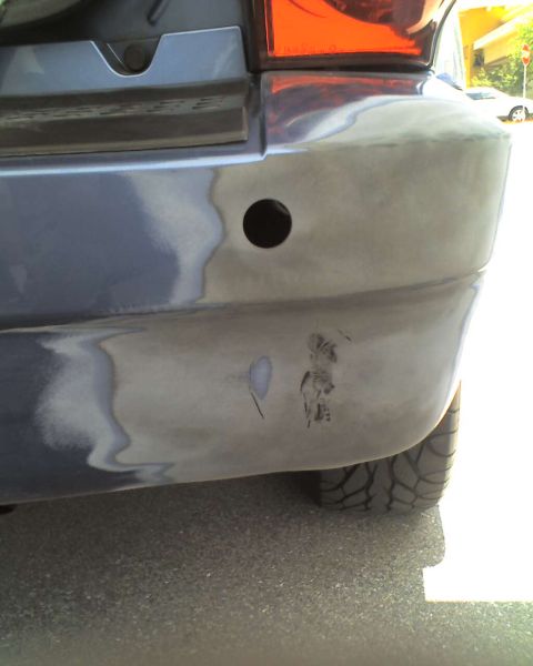 1993 Ford C-350 (Centurion Conversions) - Close-up of a vehicle's rear bumper showing a parking sensor hole and body filler.