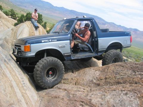 1989 Ford Bronco - This 1989 Ford Bronco is tackling a challenging off-road course with its modified suspension and tires.
