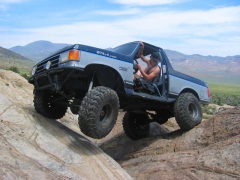 1989 Ford Bronco - A modified Ford Bronco navigates a rocky trail, its off-road capabilities.