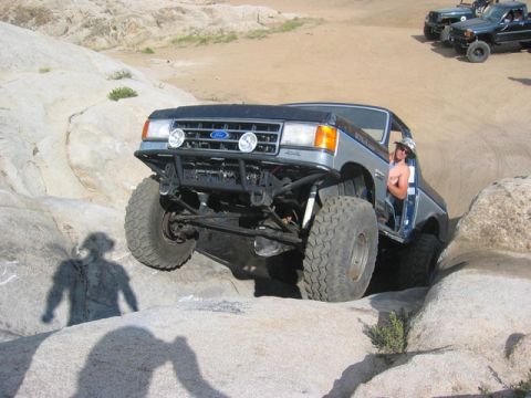 1989 Ford Bronco - Modified Ford Bronco navigating a rocky trail with other vehicles present.