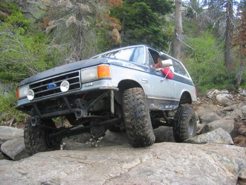 1989 Ford Bronco - This heavily modified Ford Bronco navigates a rocky trail, its off-road capabilities.
